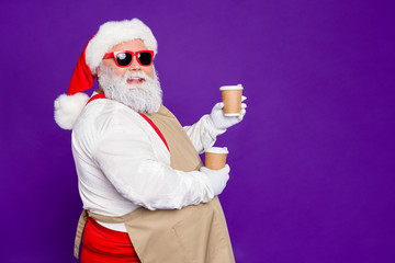 Profile side view portrait of nice cheerful cheery confident bearded Santa Claus holding in hands...