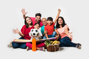 Indian Family enjoying Picnic indoors - Multi generation of asian family sitting over over white...