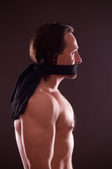 Profile view of shirtless handsome man with black band around his mouth