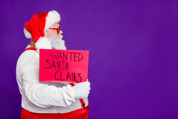 Profile side view portrait of his he nice confident serious bearded Santa showing demonstrating placard wanted search copy space isolated over bright vivid shine vibrant violet lilac background