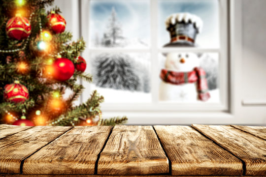 Desk of free space for your decoration and winter window background with snowman  - Powered by Adobe