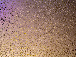 Water droplets on the glass with a colored background. Drops of water.