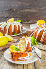 Homemade lemon bundt cake with sugar icing, fresh lemons and mint leaves, copy space