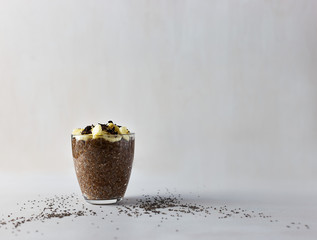 Chocolate chip pudding with banana, honey and vegetable milk on white table. Very useful and nutritious product.