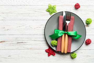 Holiday composition of Christmas dinner on wooden background. Top view of plate, utensil and festive decorations. New Year Advent concept with copy space