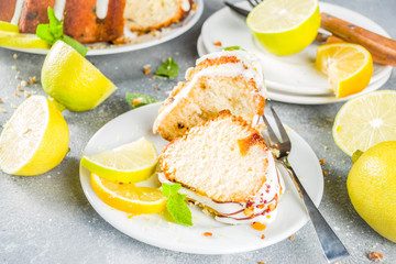 Homemade lemon bundt cake with sugar icing, fresh lemons and mint leaves, copy space