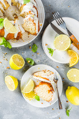 Homemade lemon bundt cake with sugar icing, fresh lemons and mint leaves, copy space
