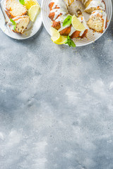 Obraz na płótnie Canvas Homemade lemon bundt cake with sugar icing, fresh lemons and mint leaves, copy space