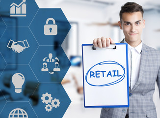 Business, technology, internet and network concept. Young businessman shows a keyword: Retail