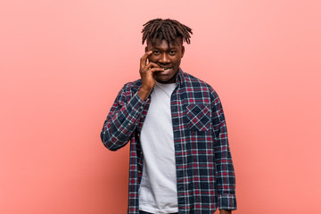Young african black man biting fingernails, nervous and very anxious.