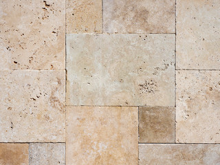 Fototapeta premium A fragment of a wall made of polished stone in pastel colors in daylight.