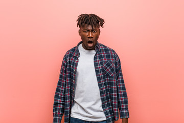 Young african black man screaming very angry and aggressive.