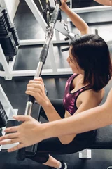 Foto op Aluminium Attractive woman doing exercise with personal trainer at gym. © ic36006