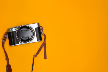 Travel concept with camera and note on orange background