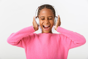 Image of funny african american girl using headphones while shouting