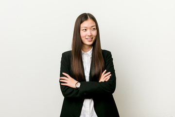 Young pretty chinese business woman smiling confident with crossed arms.