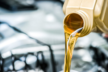 Pour motor oil to car engine. Fresh yellow liquid change with back light. Maintenance or service...