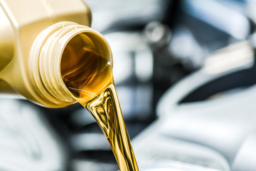 Motor oil poring. Car maintenance change and refuel yellow liquids.