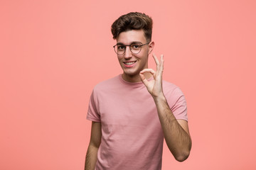 Young cool caucasian man cheerful and confident showing ok gesture.