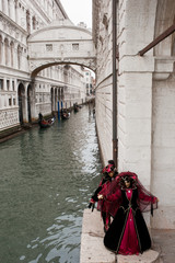 A pair of masks under the Bridge of Sighs in Venice during the Carnival, Italy