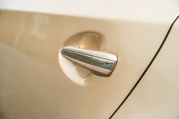 Photo of door chrome handle of car of gold color