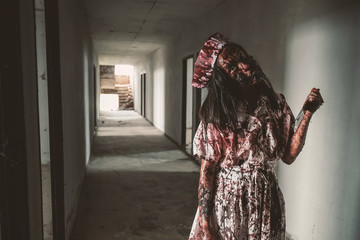 Ghost nurse woman or zombie holding the knife with resentment and malice in the building abandoned hospital.
