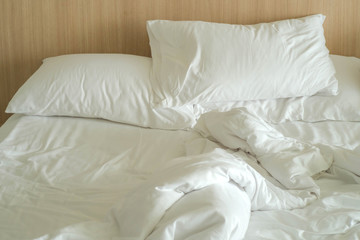 Messy white bed and pillows in the morning
