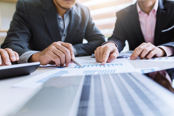 Business people hand pointing at business document during discussion at meeting.