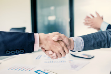 Businessmen handshake at the meeting and congratulated on the success of their business.