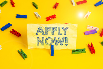 Writing note showing Apply Now. Business concept for request something officially in writing or by sending in form Colored clothespin papers empty reminder yellow floor background office