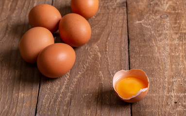 Eggs and egg yolk in the shell lie on wooden boards.