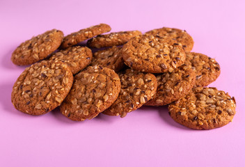 Round oatmeal cookies on a purple background.