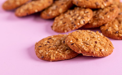 Round oatmeal cookies on a purple background.