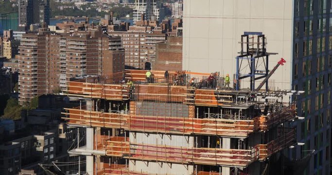 A long shot view of construction workers on a new building in midtown Manhattan, New York City.  	