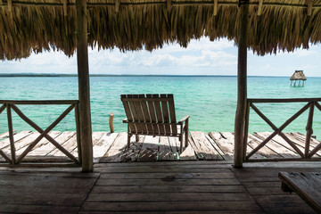 Dock with chair at lake Itza, El Remate, Guatemala
