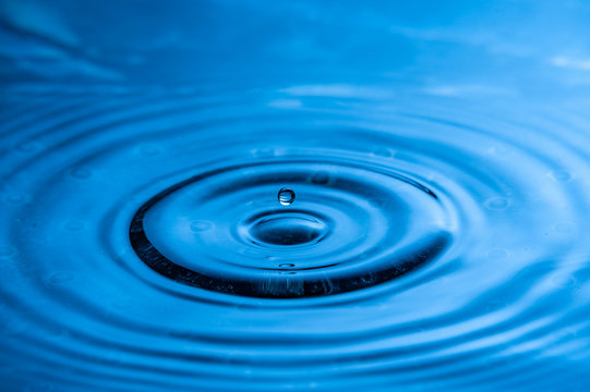 High speed water drop photography. Blue with single drop about to splash