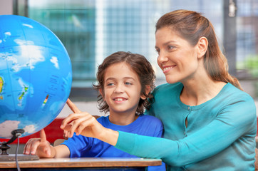 Female teacher explaining geography to her pupil