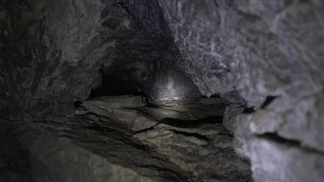 The rays of the lanterns illuminate a deep hole in the cave