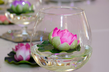 Decorative glass with Lotus on the table. Festive decorations of the dishes.