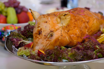 Pig roasted in a dish on the holiday table. Food for gourmets and meat pork eaters.