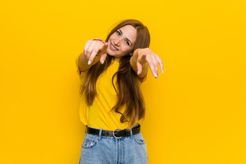 Young ginger redhead woman cheerful smiles pointing to front.