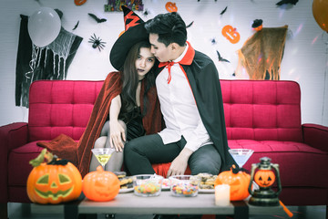 Happy couple of love in Halloween costume and makeup celebrating in Halloween night party