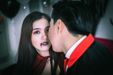 Happy couple of love in Halloween costume and makeup celebrating in Halloween night party