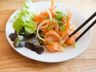 A set of sushi on a wooden table in a Japanese restaurant.Fresh salmon sliced for sushi menu.Party of friends or family eating sushi using bamboo sticks.