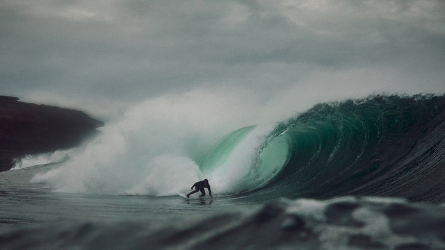 Surfer takes on big wave