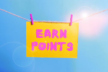 Conceptual hand writing showing Earn Points. Concept meaning getting praise or approval for something you have done Clothespin rectangle shaped paper reminder white wood desk