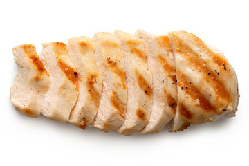Partially sliced grilled chicken breast with grill marks, ground black pepper and salt isolated on...