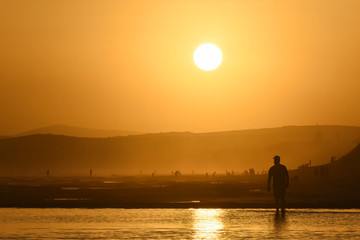 Naklejka na ściany i meble Man Watching The Sunset On Hot Summer Vacation Beach, Mossel Bay, South Africa