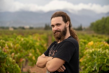 Master of wine posing in the middle of his vineyards where he produce wine
