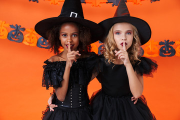 Image of multinational witch girls showing silence gesture